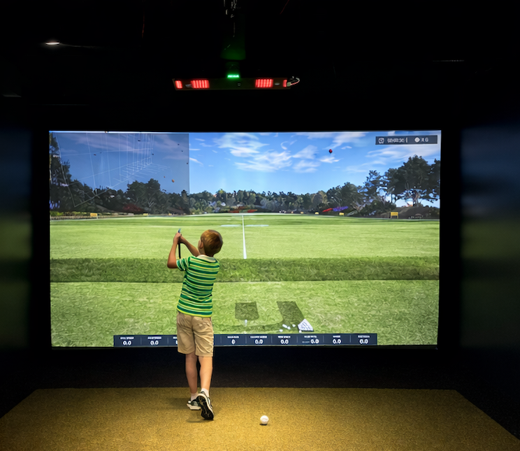 Kid playing golf at TeeBox Golf